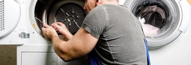 Dryer repair technician fixing a clothes dryer drum in Minneapolis, MN