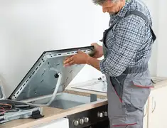 Appliance repair technician installing a built-in cooktop in Minneapolis, MN