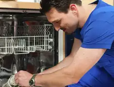 Dishwasher repair technician inspecting and servicing an open dishwasher in Minneapolis, MN