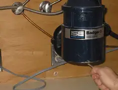 Garbage disposal repair technician tightening the mounting ring under a sink in Minneapolis, MN