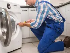 Washing machine repair technician servicing a front-load washer in Minneapolis, MN