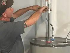 Water heater repair technician tightening supply line connections in Minneapolis, MN