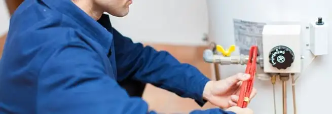 Water heater repair technician adjusting the temperature control and gas valve in Minneapolis, MN